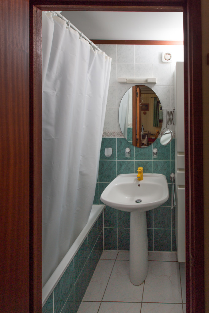 La salle de bains contient une baignoire/douche et un lavabo.